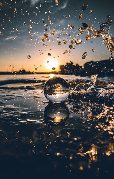 Vertical shot of a Lensball in splashing water in the sea