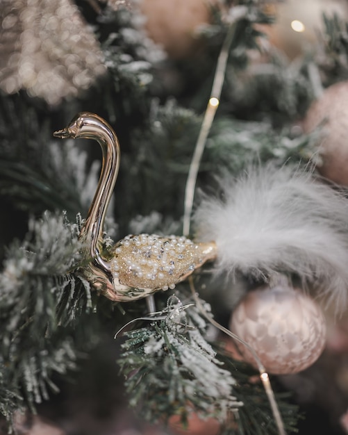 Ripresa verticale di un ornamento di cigno di lusso appeso a un albero di natale