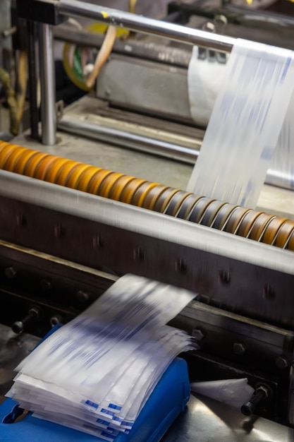 A vertical shot of a machine printing syringe labels at a\
medical production warehouse