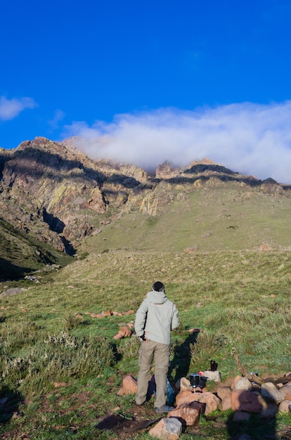 アルゼンチンのアンデス山の下に立っている男性の垂直ショット