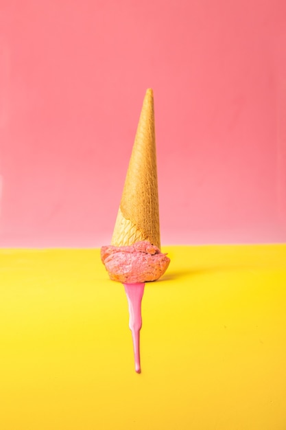 Photo vertical shot of melted pink ice cream on a colorful background