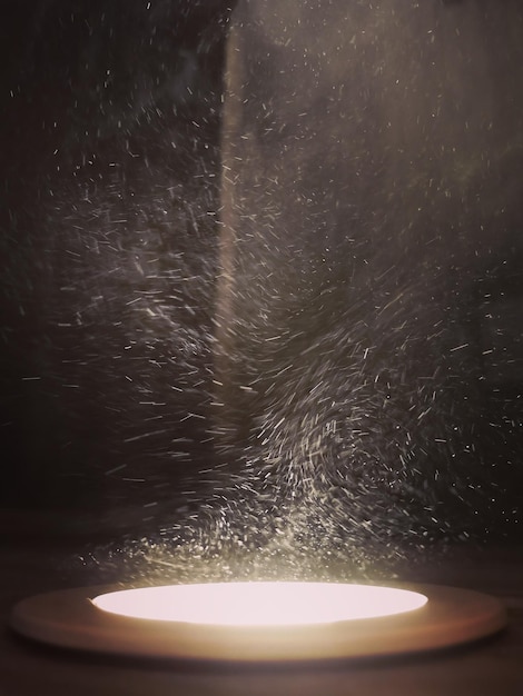 Вертикальный снимок движущихся частиц пыли в луче света