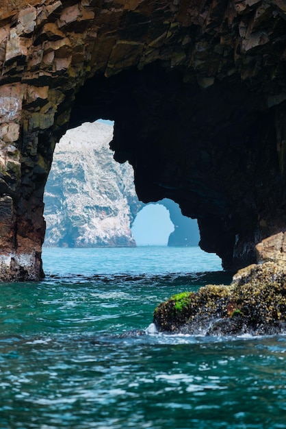 Photo vertical shot of a natural cliff arch at the ballestas islands, peru