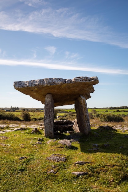 Vertical shot of Poulnabrone Dolmen in a green field in the Burren County Clare Ireland