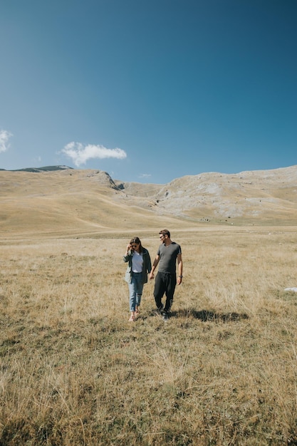 Vertical shot of a romantic view of the Caucasian young couple in the field