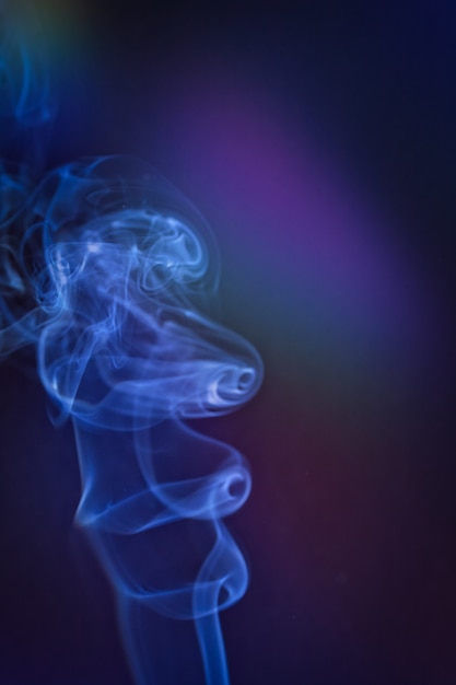 Photo a vertical shot of smoke in colorfull backlight with a blue note