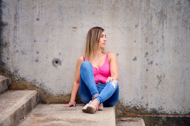 Vertical shot of a Spanish female sitting on the stairs