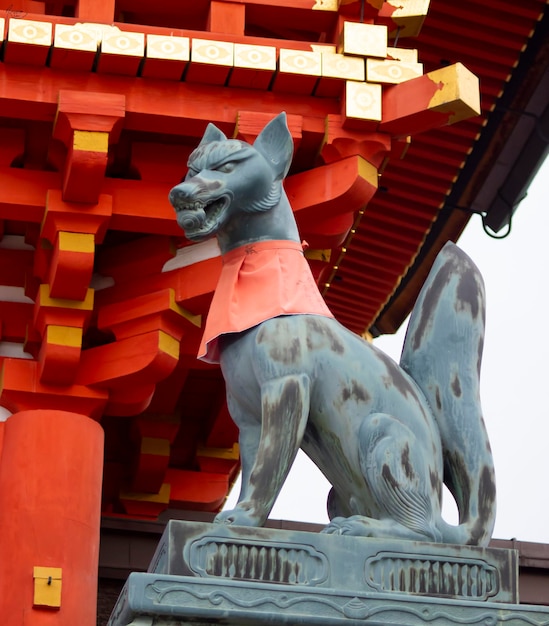 Vertical shot of a statue of fox in the temple of goddess Inari in Kyoto Japan