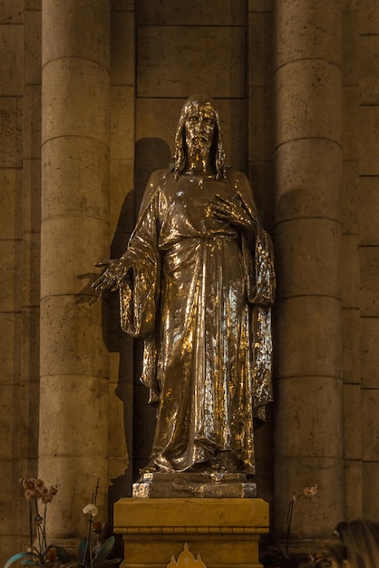 Vertical shot of the statue of Jesus inside the Basilica of the Sacred Heart of Paris France