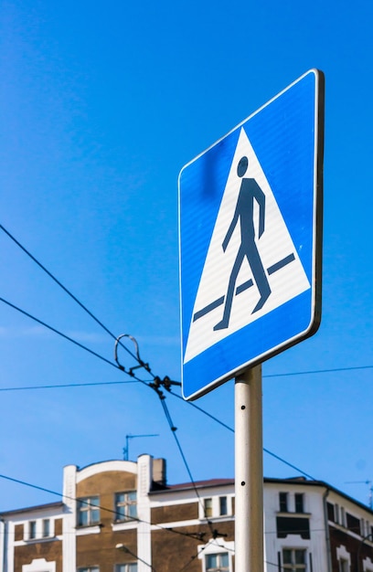 Vertical shot of a street sign showing a  pedestrian