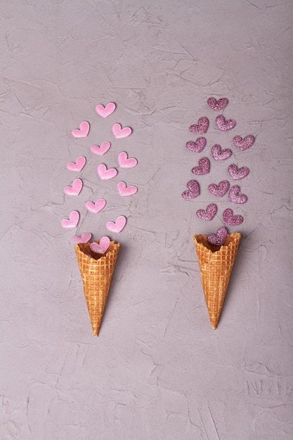 ハートバレンタインデーまたは創造的なコンセプトのピンクと紫の垂直ショットトップビューアイスクリームコーン