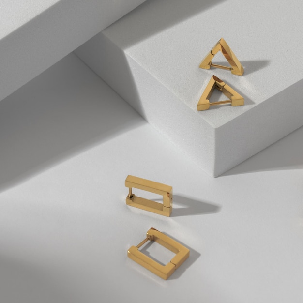 Vertical shot of two modern geometric earrings pairs on white background