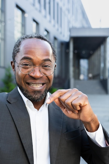 Vertical shot video call of successful businessman boss african american man outside office building