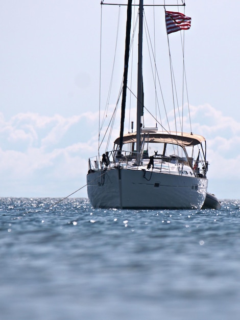 Vertical shot of a white boat sailing on the sea in summer