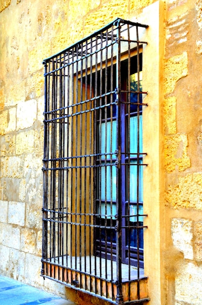 Vertical shot of the window with old rusty bars.