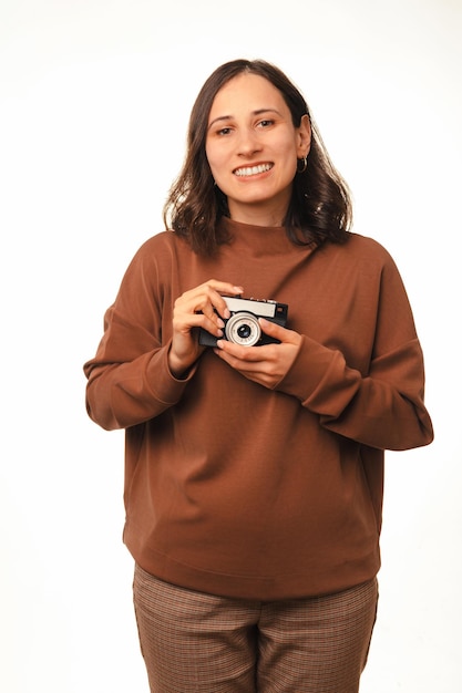 Vertical shot of a woman holding a vintage camera and learning photography