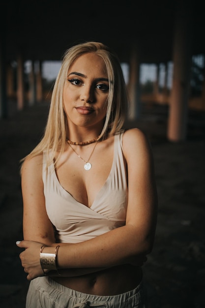 Vertical shot of a young sexy female posing in a dark abandoned building