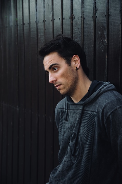 Photo vertical shot of a young south american male against the wall