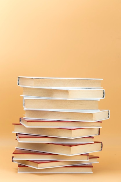 Vertical stack of books on an orange background