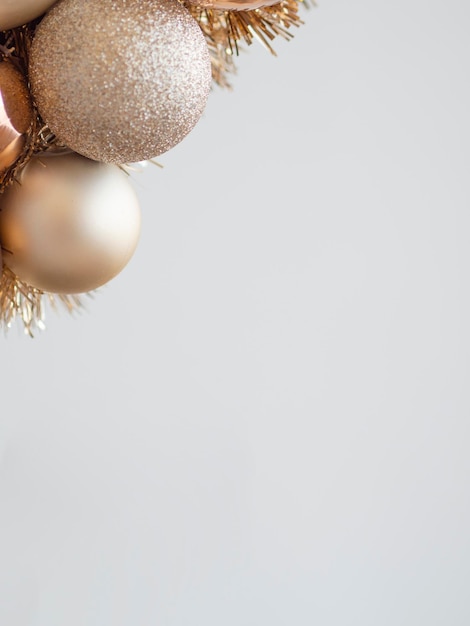 Фото Вертикальный натюрморт макет золотой рождественской еловой ветки с блестящими и матовыми шарами на сером