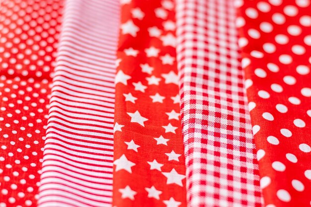 Vertical textural background of five types of red and white cotton fabric with different prints chec...