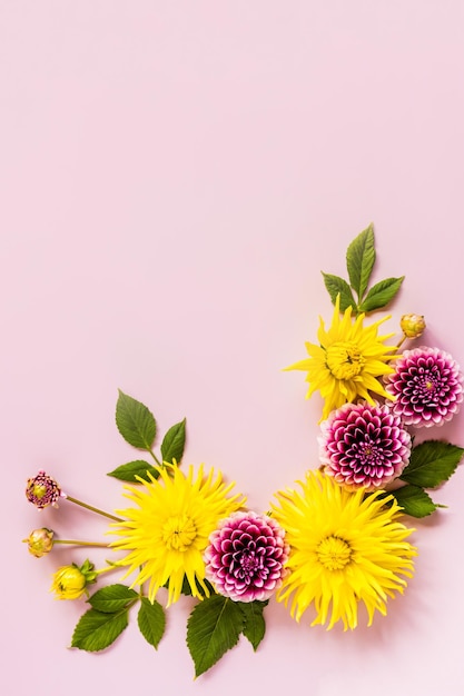 Photo vertical top view of the autumn flowers in the composition flower frame of yellow and purple dahlias a copy of the space a holiday card