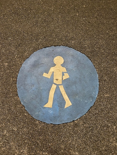 Vertical top view shot of a pedestrian sign painted on asphalt