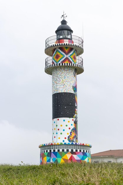 Vertical view of Cabo de Ajo Lighthouse painted by the painter Okuda San Miguel specialized in Urban Art Ajo Bareyo Municipality Cantabria Cantabrian Sea Spain Europe