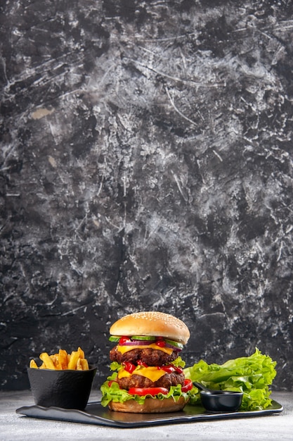 Photo vertical view of delicious homemade sandwich and fork ketchup fries green on black tray on gray distressed isolated surface