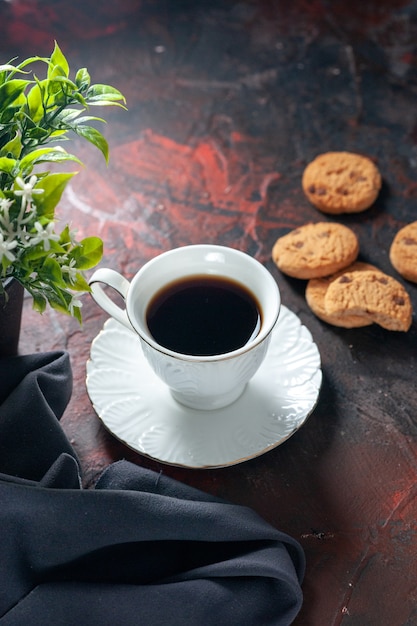 Vertical view of homemade delicious sugar cookies and flower pot a cup of coffee on dark mix colors background