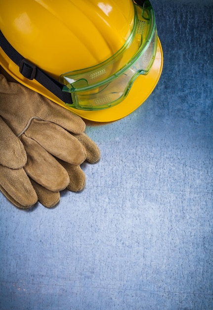 Foto vista verticale di guanti protettivi in pelle giallo casco da costruzione