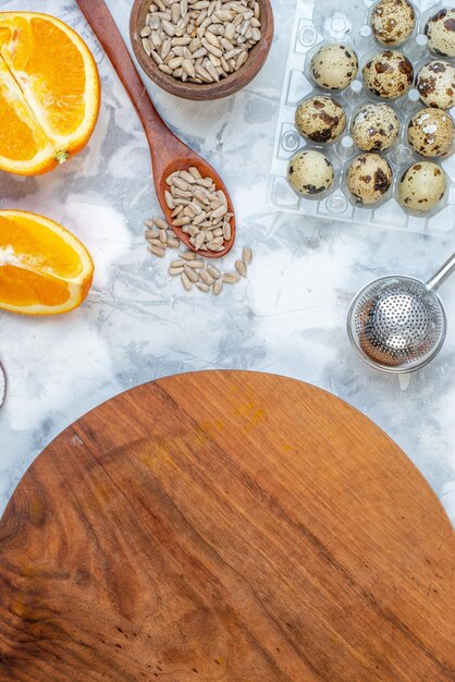 Vertical view of wooden round board and ingredients for the healthy food set on white blue table