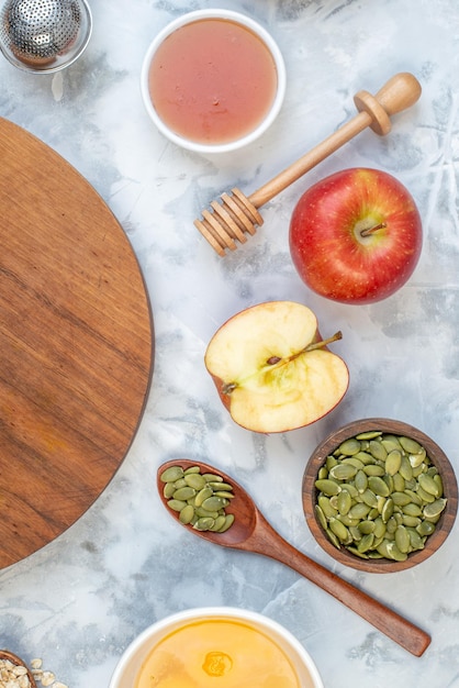 Vertical view of wooden round board and ingredients for the healthy food set on white blue table