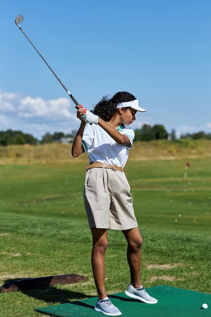 Vertical woman playing golf on green grass and swinging golf club