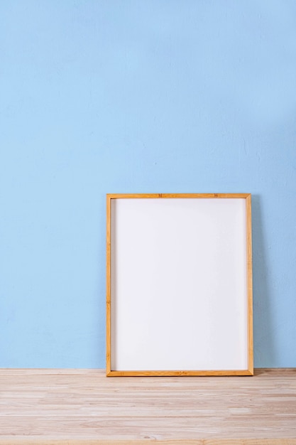 Vertical wood frame mock up on wooden floor and Light blue background