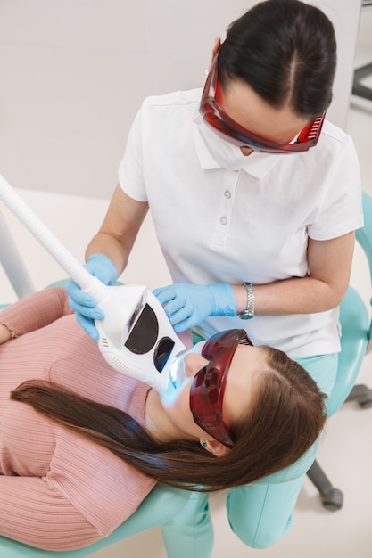 Verticale bovenaanzicht shot van een professionele tandarts tanden bleken voor vrouwelijke patiënt