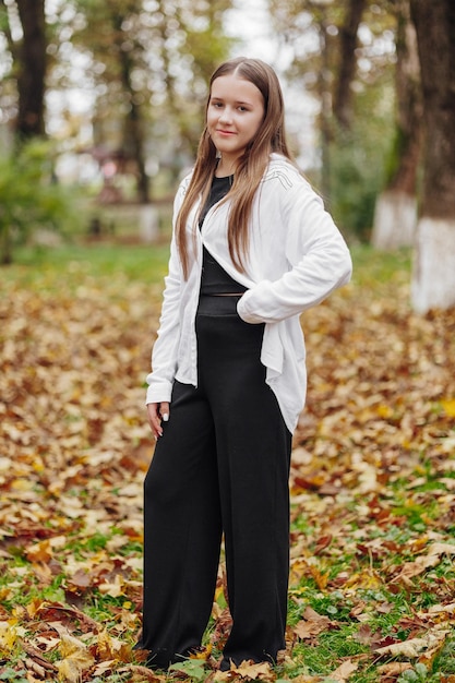 Verticale foto Mooi zorgeloos jong tienermeisje in casual kleding Portret van een mooi meisje tegen de achtergrond van de natuur met een vervaagde achtergrond