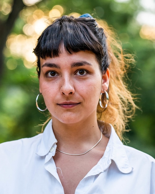 Verticale foto van een brunette vrouw in een wit overhemd