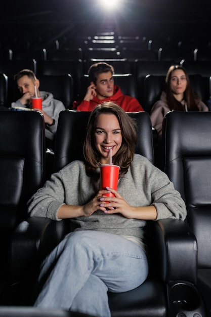 Foto verticale foto van een glimlachende jonge vrouw die naar de bioscoop kwam filmpremières