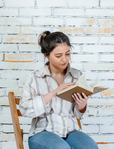 Verticale foto van een jonge dame die een boek leest Foto van hoge kwaliteit