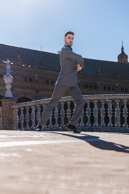 Verticale foto van een man in pak flamenco dansend alleen op een brug in Sevilla