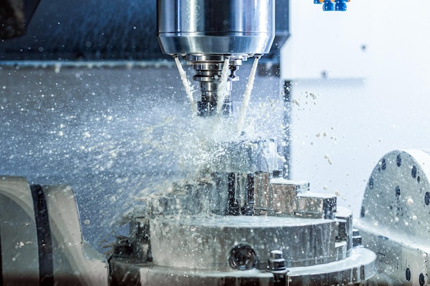 Verticale foto van industrieel nat freesproces in 5-assige cnc-machine met koelvloeistofstroom onder druk en bevriezende spatten