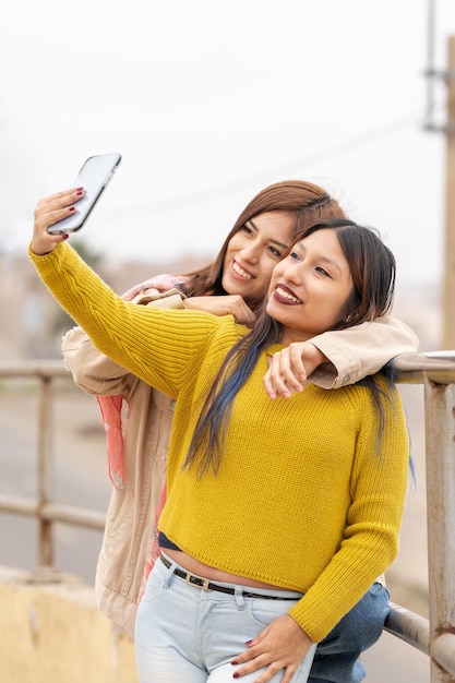 Verticale foto van twee vrienden die buiten een selfie maken