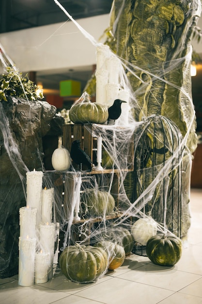 Foto verticale halloween-decoraties binnenshuis pompoenen spinnenwebben en kraaien met kaarsen fotogebied