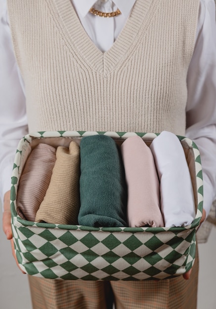 Verticale opslag van kleding in een container in de handen van een vrouw