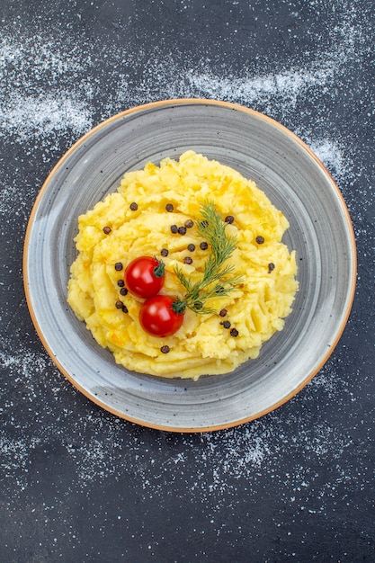 Verticale weergave van heerlijke aardappelpuree geserveerd met tomaten dille peper op witte zwarte gemengde kleur achtergrond