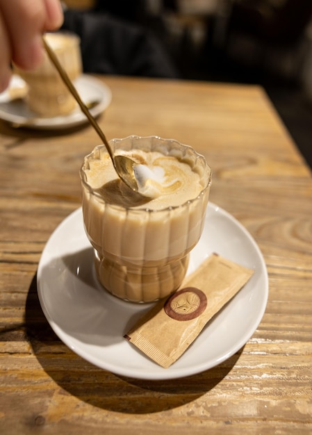 Vertikale foto met een romige cappuccino in een glazen beker