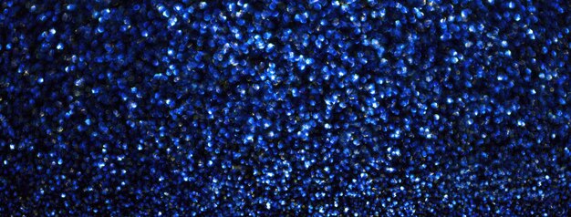 Foto vervaagde marineblauwe sprankelende achtergrond van kleine pailletten macro glinsterende ultramarine glitterende bokeh van kerstkrans vervaagde ontfocuste saffier achtergrond met zachte vervaagde