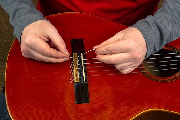 Foto vervanging en inbrengen van nylon snaren in een klassieke gitaarles voor een muzikant