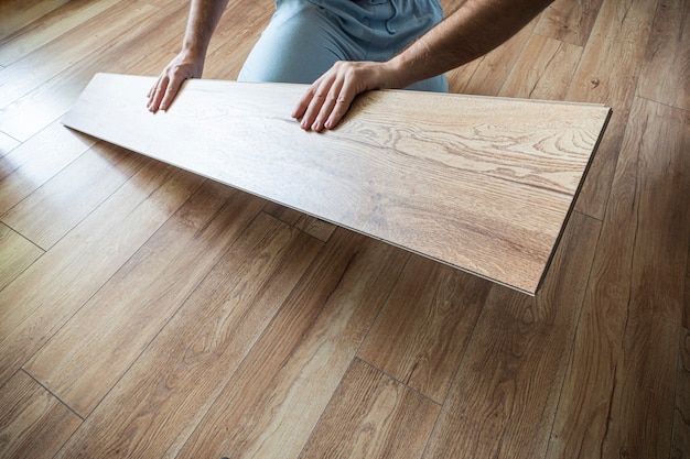 Vervanging van parket op de vloer. Man laminaat leggen in een huis.